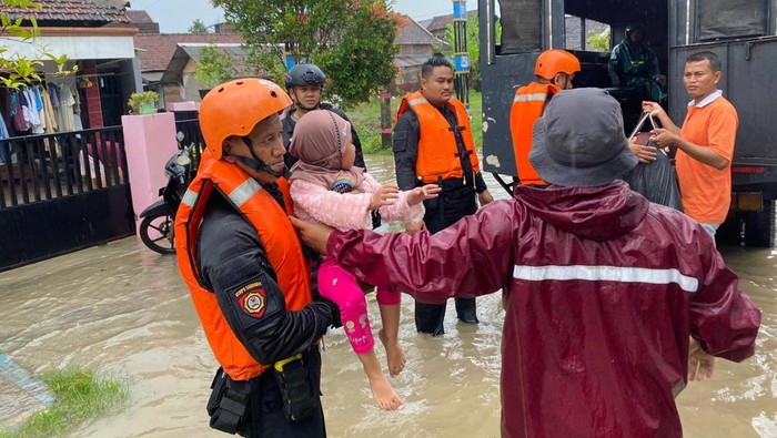 Polisi saat mengevakuasi korban banjir di Jati, Kudus, Kamis (14/3/2024).