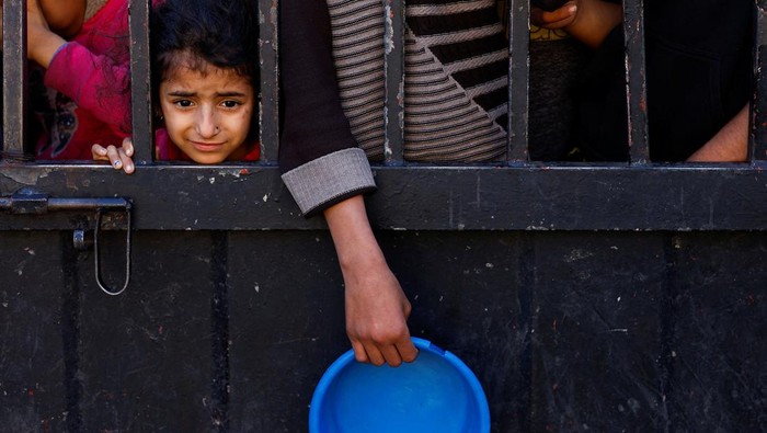 Palestinians wait to receive food during the Muslim holy fasting month of Ramadan, as the conflict between Israel and Hamas continues, in Rafah, in the southern Gaza Strip March 13, 2024. REUTERS/Mohammed Salem