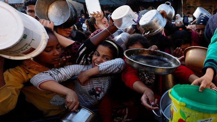 Palestinians wait to receive food during the Muslim holy fasting month of Ramadan, as the conflict between Israel and Hamas continues, in Rafah, in the southern Gaza Strip March 13, 2024. REUTERS/Mohammed Salem