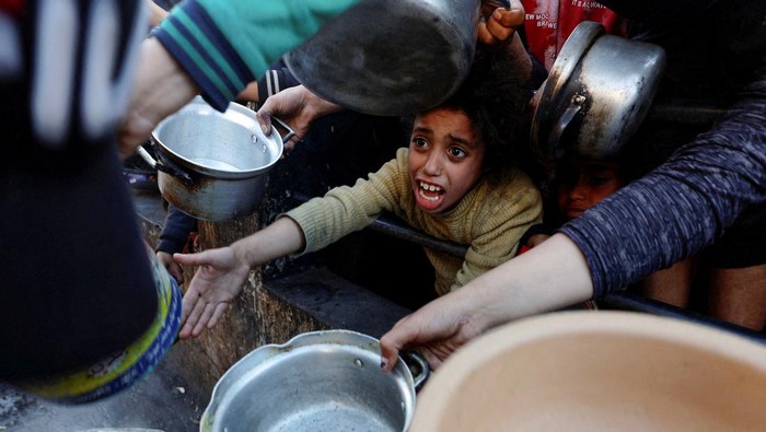 Palestinians wait to receive food during the Muslim holy fasting month of Ramadan, as the conflict between Israel and Hamas continues, in Rafah, in the southern Gaza Strip March 13, 2024. REUTERS/Mohammed Salem