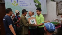 Suharji Gasali Wakil Ketua Yayasan Mahija Parahita Nusantara, Triyoni Prijosoesilo, Direktur Public Affairs, Communication and Sustainability PT Coca Cola Indonesia memberikan bantuan paket sembako di Jakarta, Kamis (14/3/2024).