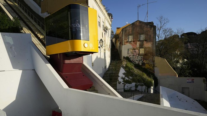 A passenger looks out from the just inaugurated funicular that connects the top of the Graca hill neighborhood with downtown Lisbon, Wednesday, March 13, 2024. The new funicular that can carry fourteen passengers joins three others operating in different Lisbon hills since the late 19th century. (AP Photo/Armando Franca)