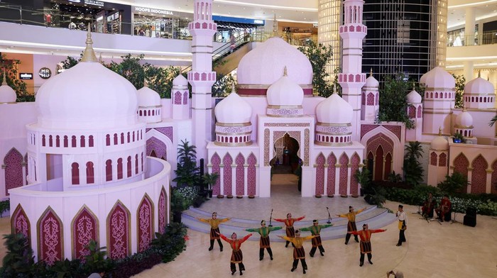 People pose for a photograph near the decoration depicting a Mosque at the Dawn Sanctuary event during the holy fasting month of Ramadan at the Senayan City shopping mall in Jakarta, Indonesia, March 13, 2024. REUTERS/Ajeng Dinar Ulfiana