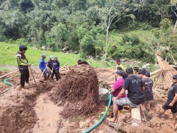 Beberapa warga yang membantu membersihkan material longsor. Tapi, tebalnya longsor hingga selutut kaki orang dewasa membuat warga sedikit kesulitan. (Ahmad Firizqi Irwan/detikBali)