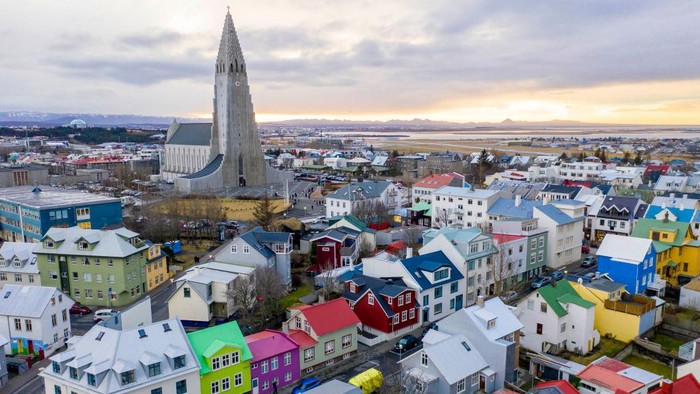 Wide landscape views of buildings, cars, people, homes, apartments, mountains, streets, water, and businesses are seen in Reykjavik, Iceland on December 18, 2018. The Hallgrimskirkja church is predominately centered in the capital, which is the largest city of the island of Iceland.  (Photo by Patrick Gorski/NurPhoto via Getty Images)