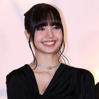 Tatanan rambut yang disanggul, poni jatuh ke depan dan beberapa helai rambut dibiarkan menjuntai, membingkai wajah Lisa dengan sempurna. Foto: Han Myung-Gu/Getty Images