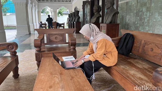 Hafizah (22) salah satu Mahasiwa UNS yang memanfaatkan internet grtis di Loji Gandrung, Jumat (15/3/2024).