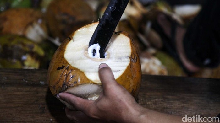 Pedagang mengupas kelapa muda di kawasan Pamulang, Tangerang Selatan, Jumat (15/3/2024). Permintaan kelapa muda tengah meningkat saat bulan Ramadan.