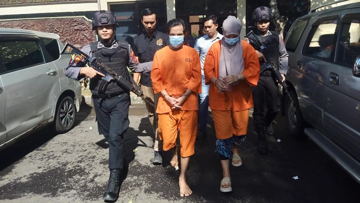 Pasangan suami istri (pasutri) saat digiring anggota Polres Jembrana atas kasus penipuan dengan modus ritual mendatangkan atau menggandakan uang di Mapolres Jembrana, Jumat (15/3/2024).