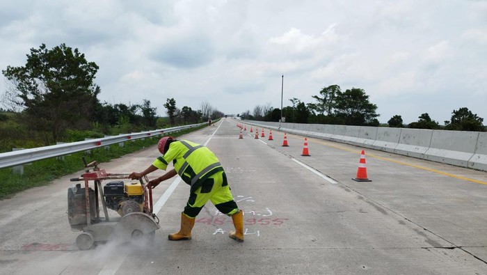 Petugas melakukan perbaikan jalan tol terpeka.