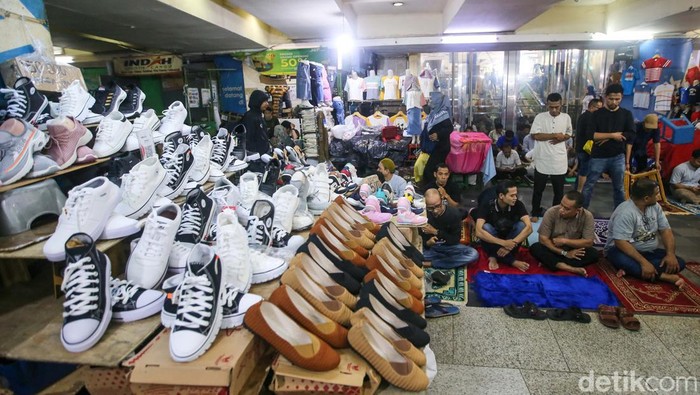 Meski tengah berjualan, pedagang Tanah Abang tetap melaksanakan salat Jumat. Salat dilaksanakan di antara lapak-lapak dagangan.