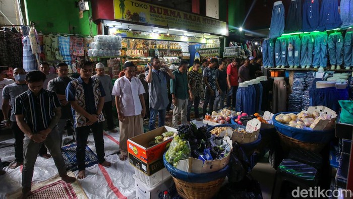 Meski tengah berjualan, pedagang Tanah Abang tetap melaksanakan salat Jumat. Salat dilaksanakan di antara lapak-lapak dagangan.