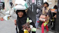 Orang-orang membawa bahan makanan di Sanaa, Yaman, Kamis (14/3/2024).  