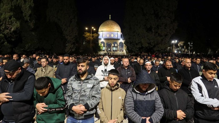 Muslim worshippers perform the evening 
