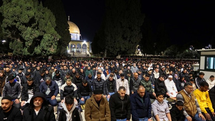 Muslim worshippers perform the evening 