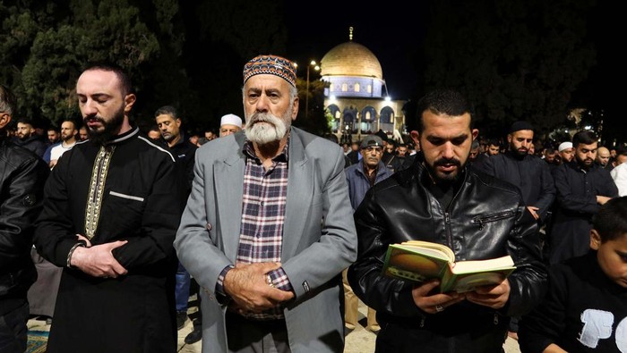 Muslim worshippers perform the evening 