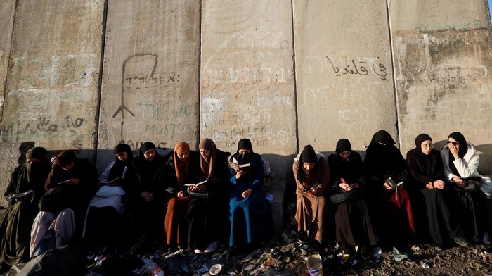 Palestinians wait at an Israeli checkpoint to make their way to Jerusalem's Al-Aqsa compound, also known to Jews as the Temple Mount, to attend Friday prayers during Ramadan, at the Qalandia checkpoint in the Israeli-occupied West Bank March 15, 2024. REUTERS/Mohamad Torokman