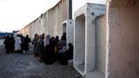 Mereka menunggu di tembok perbatasan yang dibangun Israel.  