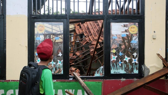 Dua pelajar melihat atap ruang kelas sekolah yang ambruk di Sekolah Dasar Negeri (SDN) Kedaung, Sawangan, Depok, Jawa Barat, Sabtu (16/3/2024). Ambruknya atap ruang kelas tersebut akibat diguyur hujan deras pada, Jumat (15/3/2024), tidak ada korban jiwa dalam peristiwa tersebut. ANTARA FOTO/Muhammad Iqbal/wpa.