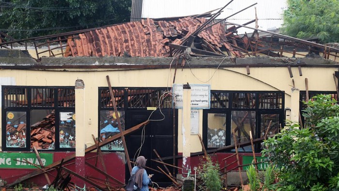 Dua pelajar melihat atap ruang kelas sekolah yang ambruk di Sekolah Dasar Negeri (SDN) Kedaung, Sawangan, Depok, Jawa Barat, Sabtu (16/3/2024). Ambruknya atap ruang kelas tersebut akibat diguyur hujan deras pada, Jumat (15/3/2024), tidak ada korban jiwa dalam peristiwa tersebut. ANTARA FOTO/Muhammad Iqbal/wpa.