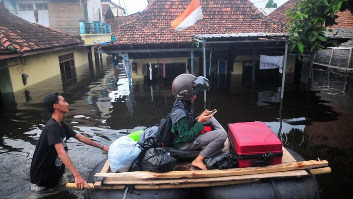 Banjir di Kudus meluas Warga melintasi jalan yang tergenang banjir dengan perahu rakit di Dukuh Tanggulangin, Jati Wetan, Kudus, Sabtu (16/3/2024). Menurut data BPBD setempat, bencana banjir sejak Kamis (14/3) akibat intensitas hujan yang tinggi serta meluapnya sungai Wulan tersebut meluas dan merendam 10.430 rumah di 29 desa dari lima kecamatan dan sebanyak 32.952 jiwa terdampak serta 911 jiwa mengungsi. ANTARA FOTO/Yusuf Nugroho/YU