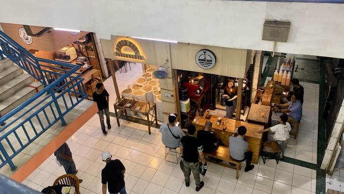 Jika termasuk dalam penggemar kopi, Traveller tidak boleh melewati kios kopi ini. Dunia Kopi di Pasar Santa Jakarta Selatan menjual berbagai jenis kopi.