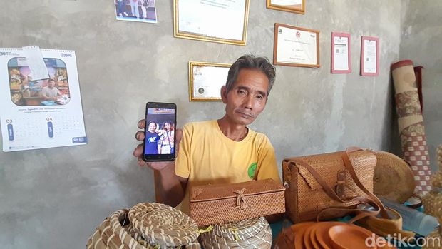 Misman bersama tas dan kerajinan buatannya.