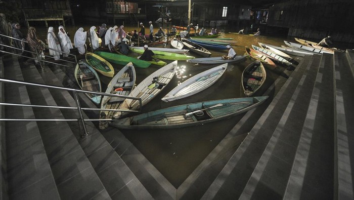Umat muslim bersiap menggunakan perahu usai melaksanakan shalat Tarawih di Masjid Riyadhul Abidin, Ulu Gedong, Jambi, Jumat (15/3/2024). Banjir yang telah merendam kawasan itu sejak tiga bulan terakhir dan melumpuhkan akses jalan darat tidak menyurutkan umat muslim setempat untuk melaksanakan ibadah shalat Tarawih berjamaah di masjid. ANTARA FOTO/Wahdi Septiawan/foc.