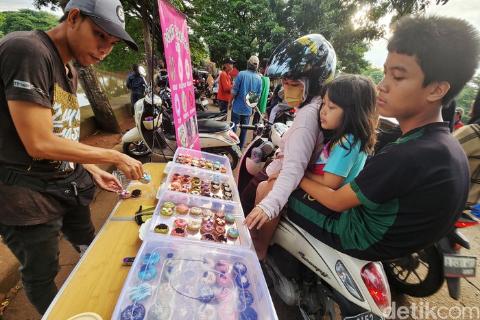 Sejumlah warga berburu takjil sembari menunggu waktu berbuka puasa (ngabuburit) di Jl Inspeksi Pesanggrahan, Jakarta Selatan, Minggu (17/3/2024). Berbagai jajanan dan foodstreet hingga baju serta wahana permainan ditawarkan di pasar tiban ini. Keramaian ini terlihat saat Ramadan terutama menjelang berbuka puasa.