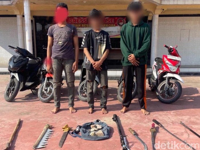 Ketiga remaja bersama barang bukti sejumlah senjata tajam saat diamankan di Polres Asahan. (Perdana Ramadhan / detikSumut)