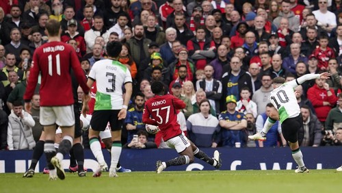 Liverpools Alexis Mac Allister, right, scores his sides opening goal during the FA Cup quarterfinal soccer match between Manchester United and Liverpool at the Old Trafford stadium in Manchester, England, Sunday, March 17, 2024. (AP Photo/Dave Thompson)
