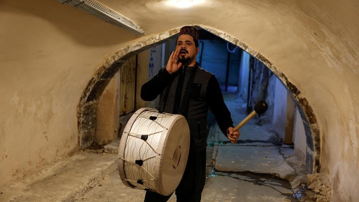 Mesaharty Ghofran Thamer (32), berkeliling untuk membangunkan warga di Mosul, Irak, Jumat (15/3/2024).