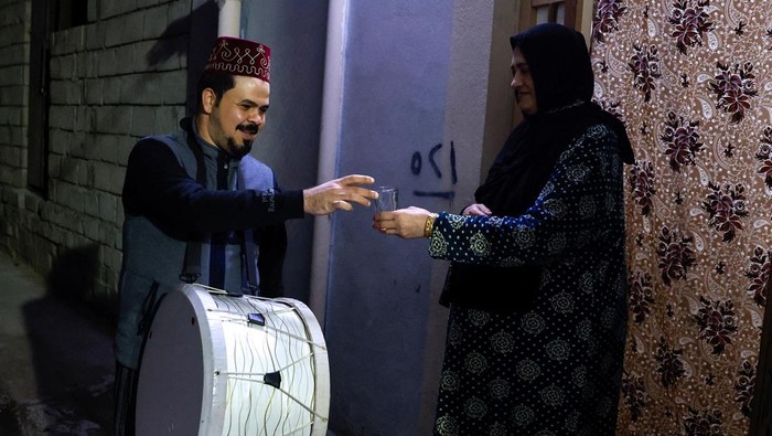 Mesaharty Ghofran Thamer (32), berkeliling untuk membangunkan warga di Mosul, Irak, Jumat (15/3/2024).