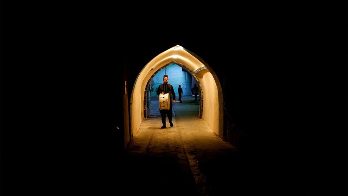 Mesaharty Ghofran Thamer (32), berkeliling untuk membangunkan warga di Mosul, Irak, Jumat (15/3/2024).