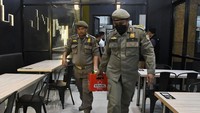 Petugas gabungan mengamankan botol-botol berisi minuman keras dalam razia tersebut.