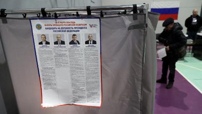 An information poster with images and biographies of the four candidates, including Russian President Vladimir Putin, is seen at a polling station during Russias presidential election in Yekaterinburg in the Urals on March 17, 2024. (Photo by Anna YURIEVA / AFP)