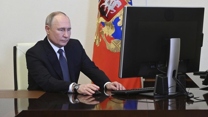 Presiden Rusia Vladimir Putin menggunakan hak suaranya dalam pilpres secara online di Kremlin. Capres petahana kemudian tersenyum usai memberikan hak suaranya.