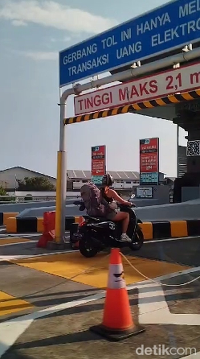 Seorang turis asing mengendarai motor dan masuk jalur mobil di Tol Bali Mandara, Badung, Bali, Minggu (17/3/2024). (Gangsar Parikesit/detikBali)