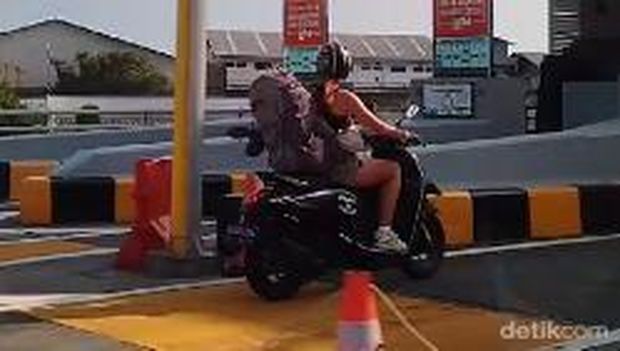 Seorang turis asing mengendarai motor dan masuk jalur mobil di Tol Bali Mandara, Badung, Bali, Minggu (17/3/2024). (Gangsar Parikesit/detikBali)