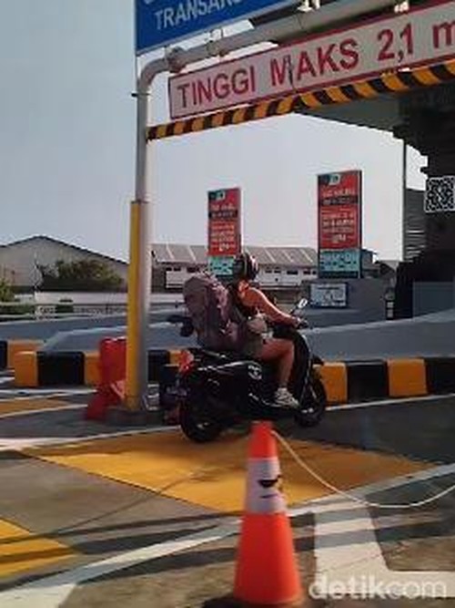 Seorang turis asing mengendarai motor dan masuk jalur mobil di Tol Bali Mandara, Badung, Bali, Minggu (17/3/2024). (Gangsar Parikesit/detikBali)