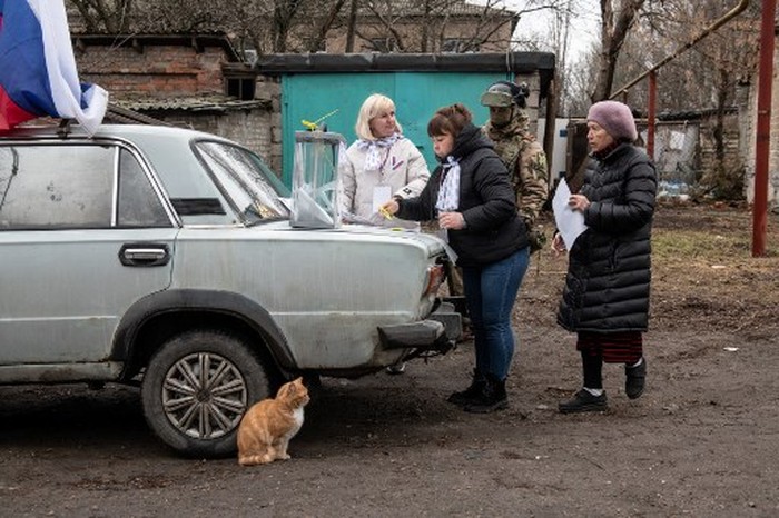 Members of a local election commission, accompanied by servicemen, visit voters during early voting in Russias presidential election in Donetsk, Russian-controlled Ukraine, amid the Russia-Ukraine conflict on March 14, 2024. (Photo by STRINGER / AFP)