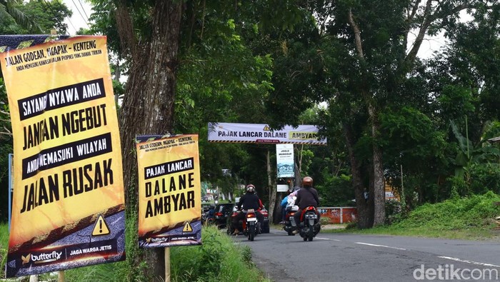 Warga di sepanjang Jalan Godean, Sleman, memasang baliho protes karena jalan berlubang, Minggu (17/3/2024).