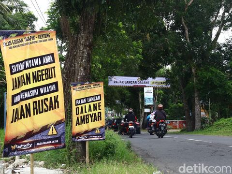 Warga di sepanjang Jalan Godean, Sleman, memasang baliho protes karena jalan berlubang, Minggu (17/3/2024).