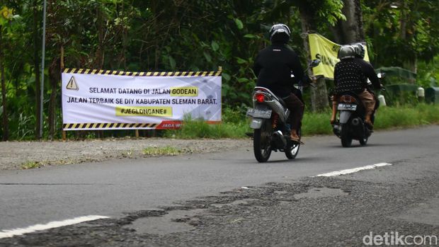 Warga di sepanjang Jalan Godean, Sleman, memasang baliho protes karena jalan berlubang, Minggu (17/3/2024).