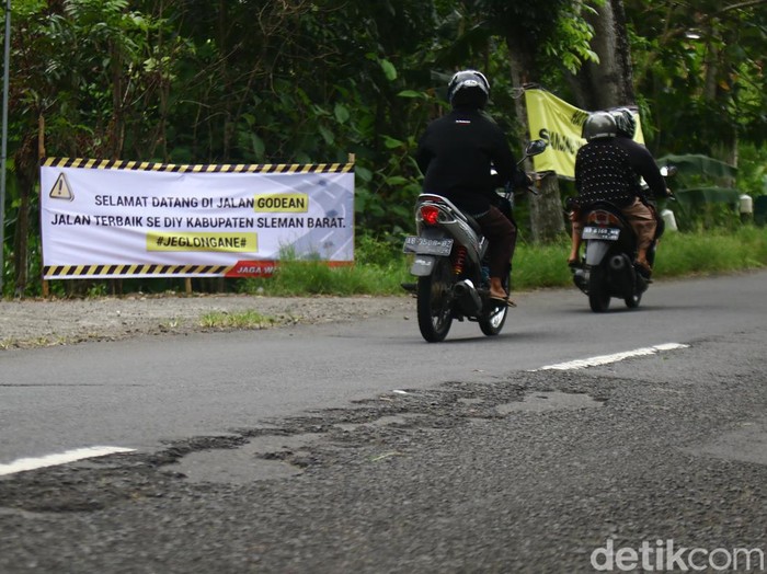 Warga di sepanjang Jalan Godean, Sleman, memasang baliho protes karena jalan berlubang, Minggu (17/3/2024).