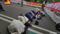 Beberapa massa terlihat menunaikan salat saat berdemo.