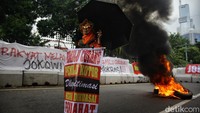 Seorang peserta aksi memamerkan poster saat berunjuk rasa depan Gedung KPU RI, Jl Imam Bonjol, Jakarta, Senin (18/3/2024).