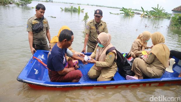 Petugas kesehatan saat menerobos banjir demi obati warga Desa Setrokalangan Kecamatan Kaliwungu yang kebanjiran, Senin (18/3/2024).