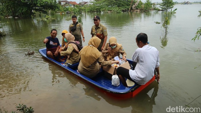 Petugas kesehatan saat menerobos banjir demi obati warga Desa Setrokalangan Kecamatan Kaliwungu yang kebanjiran, Senin (18/3/2024).
