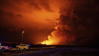 Lava mengalir menuju ke selatan menuju tanggul yang dibangun untuk melindungi desa nelayan Grindavik, Islandia. (AP Photo/Marco di Marco)